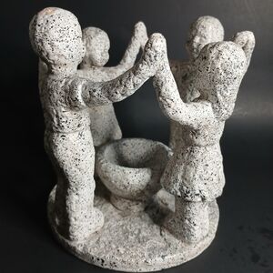 Gray Stone Sculpture of Children Holding Hands